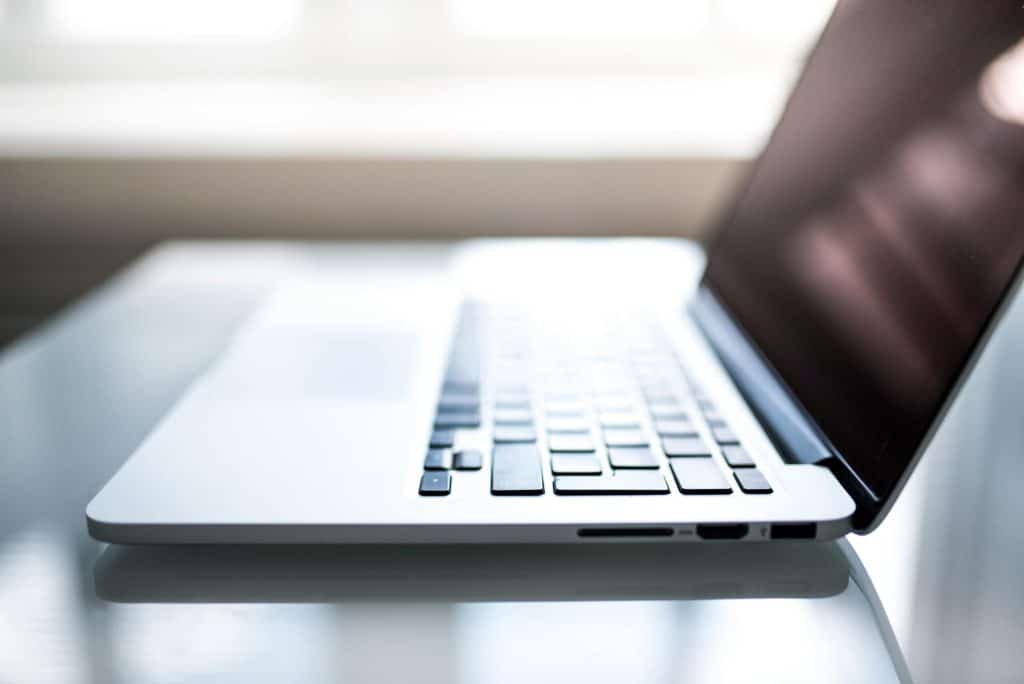Free Elegant side view of a laptop on a glossy table with natural lighting indoors. Stock Photo